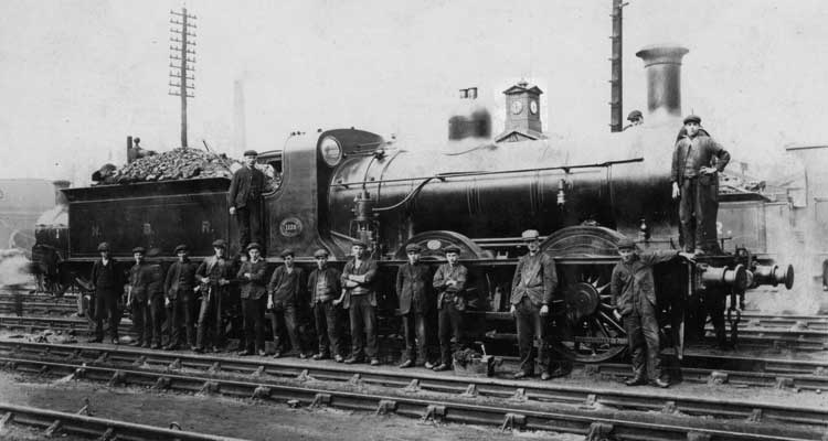 NBR 0-6-0 No 1128 is the backdrop to these 16 men at an unidentified shed